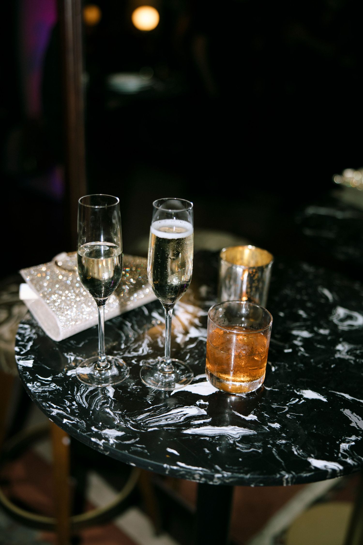 Champagne glasses and drinks arranged on a luxurious black marble table.