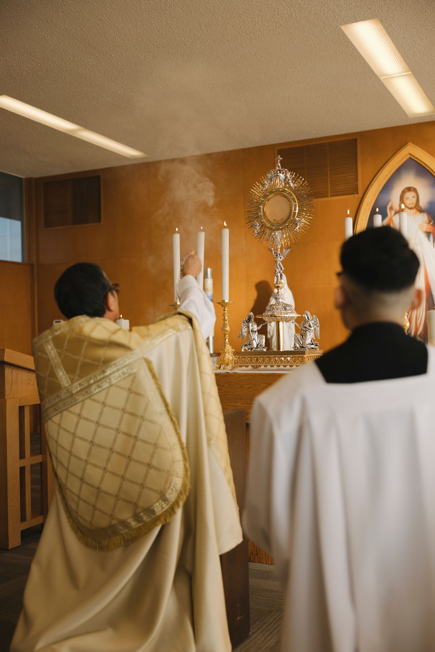 Religious ceremony in progress with clergy members in traditional vestments near an ornate altar.