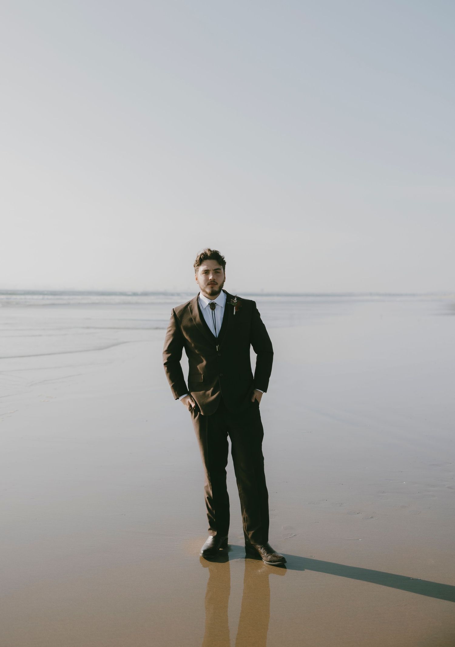 Classic wedding portraits taken against a minimalist beach landscape.
