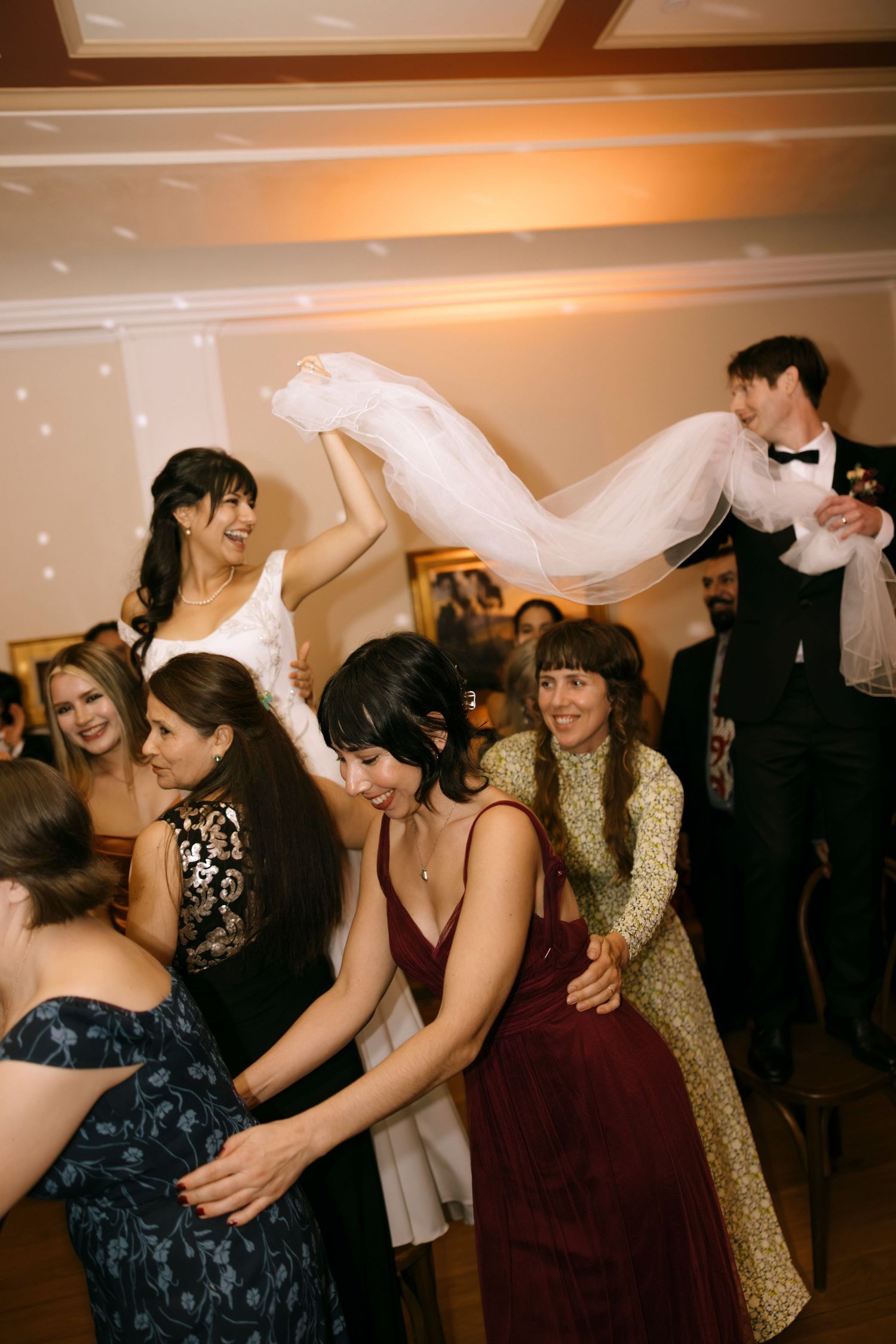 Guests dancing and celebrating at a wedding reception with flowing movements.