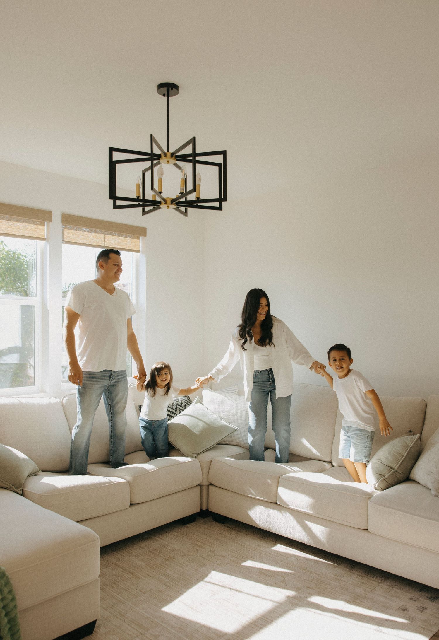 Family enjoying quality time together in a minimalist white living room with modern decor.