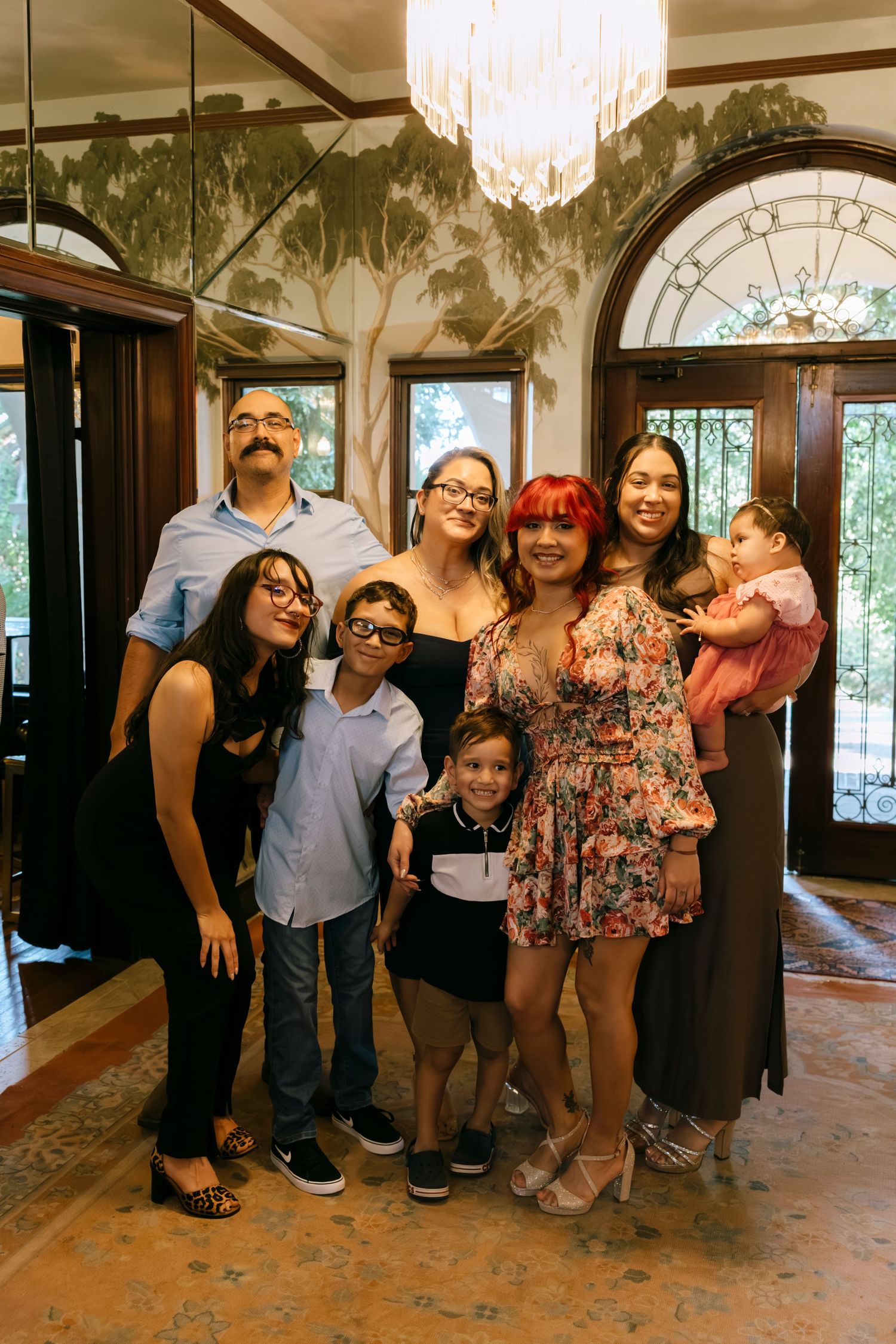 Group photo of family members gathered under a chandelier in formal attire.