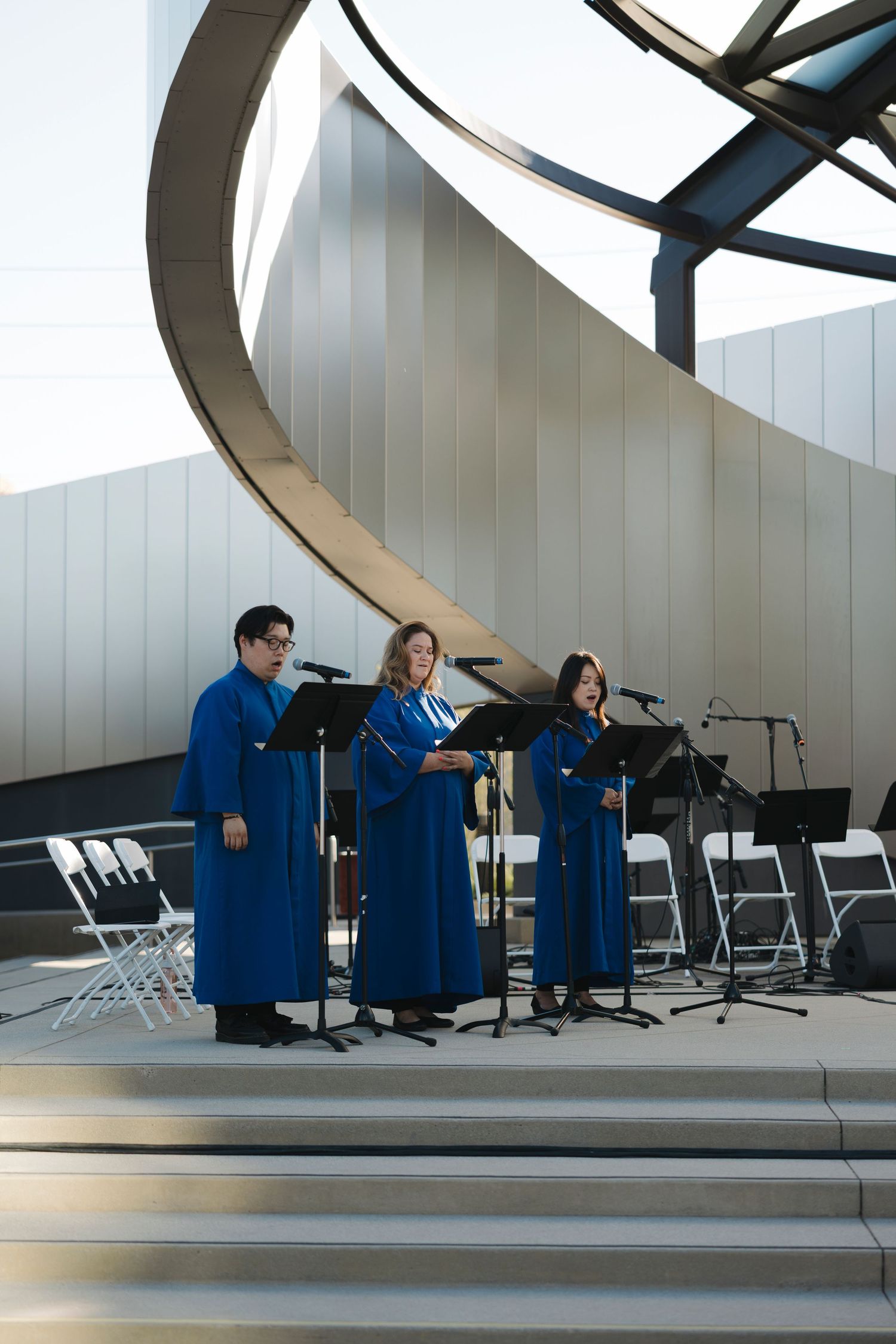 Musicians performing under a curved architectural structure with modern design elements.