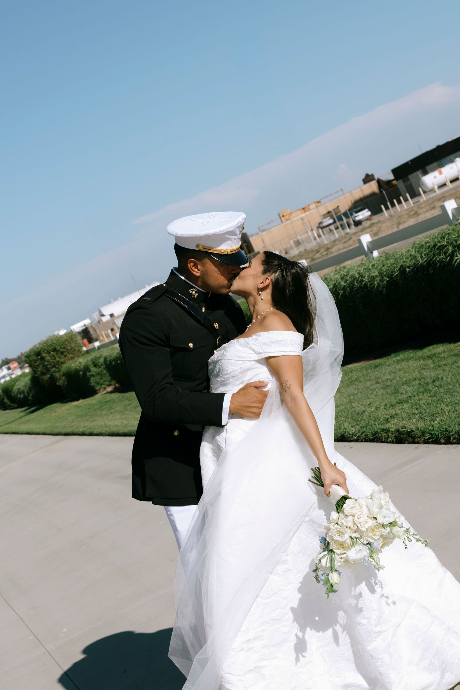A romantic wedding moment captured outdoors with mountains visible in the distance.