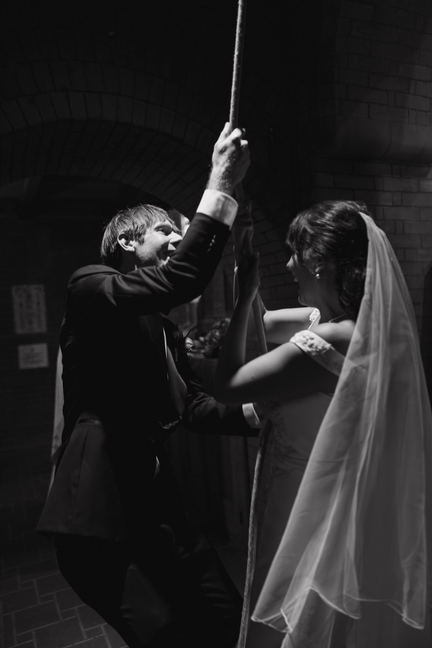 Wedding couple performs energetic dance moves in dramatic lighting.