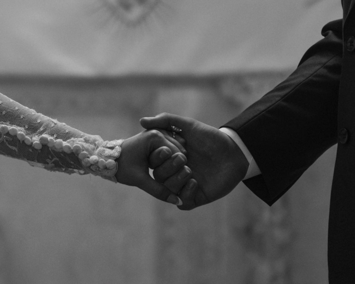 Close-up of hands during wedding ceremony ritual.