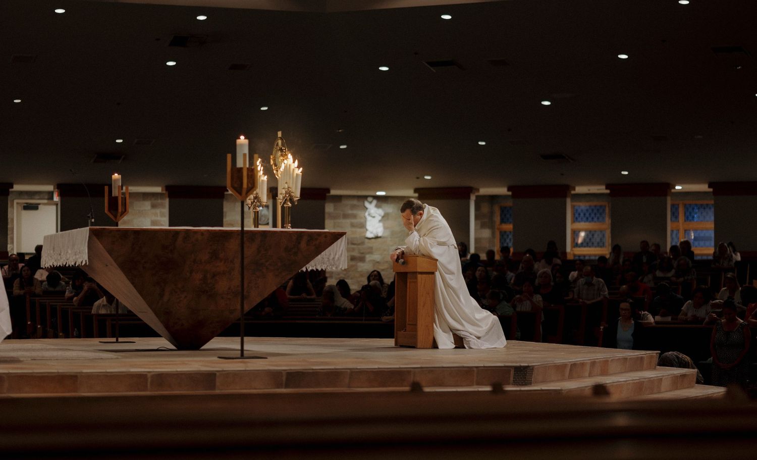 Dark interior view of church altar during religious ceremony.