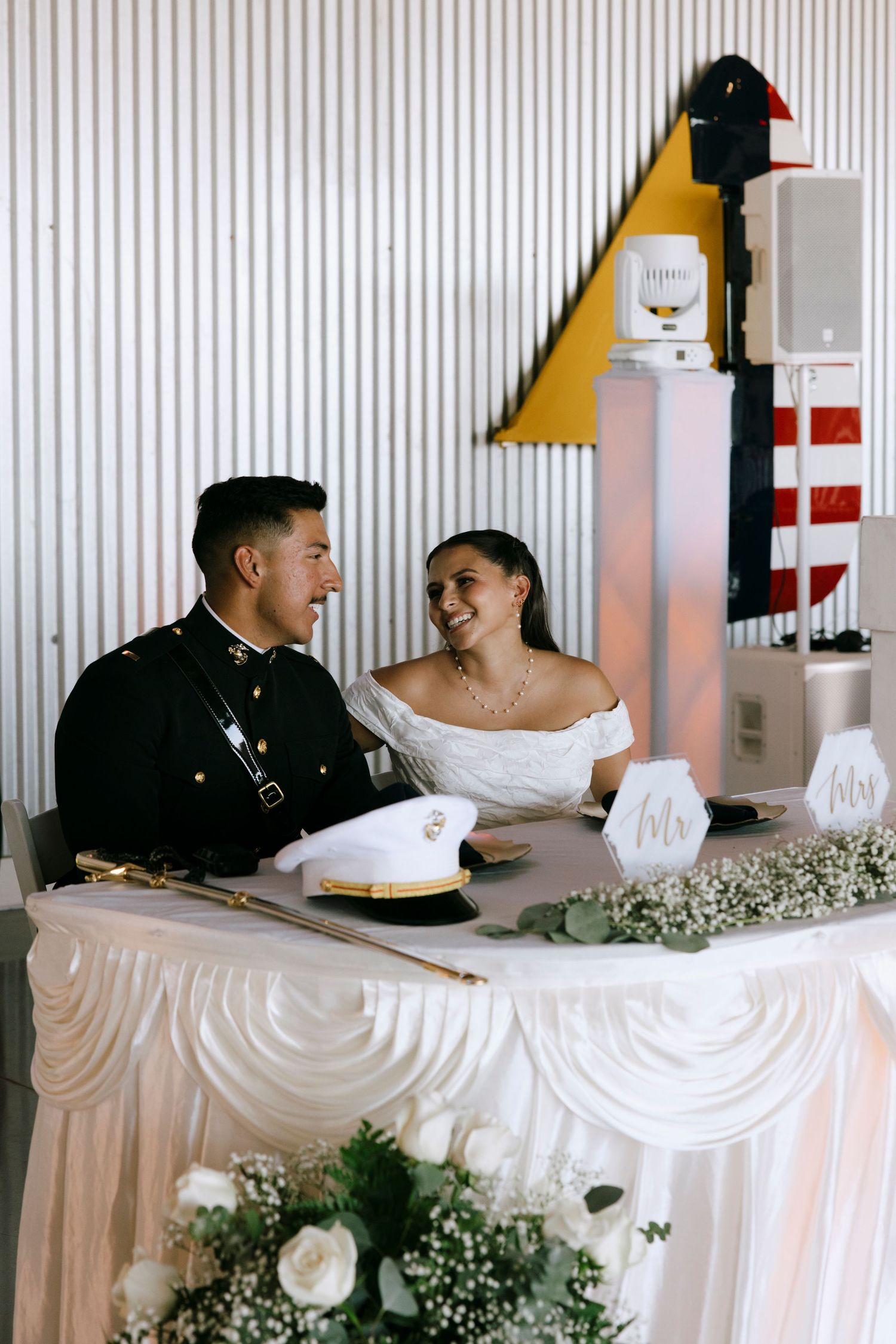 Couple shares joyful moment at their wedding reception head table.