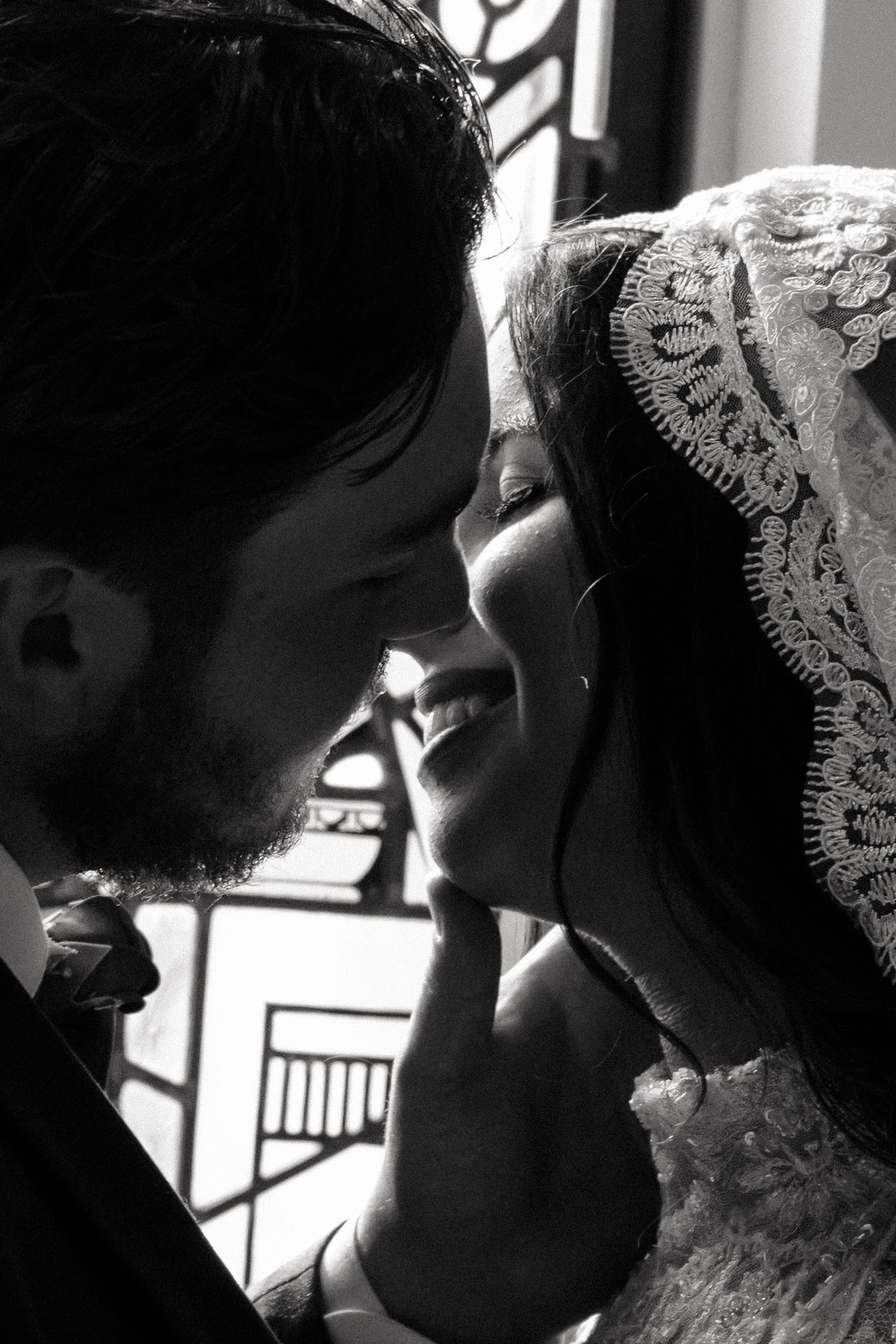 An intimate black and white close-up of a couple sharing a tender moment.