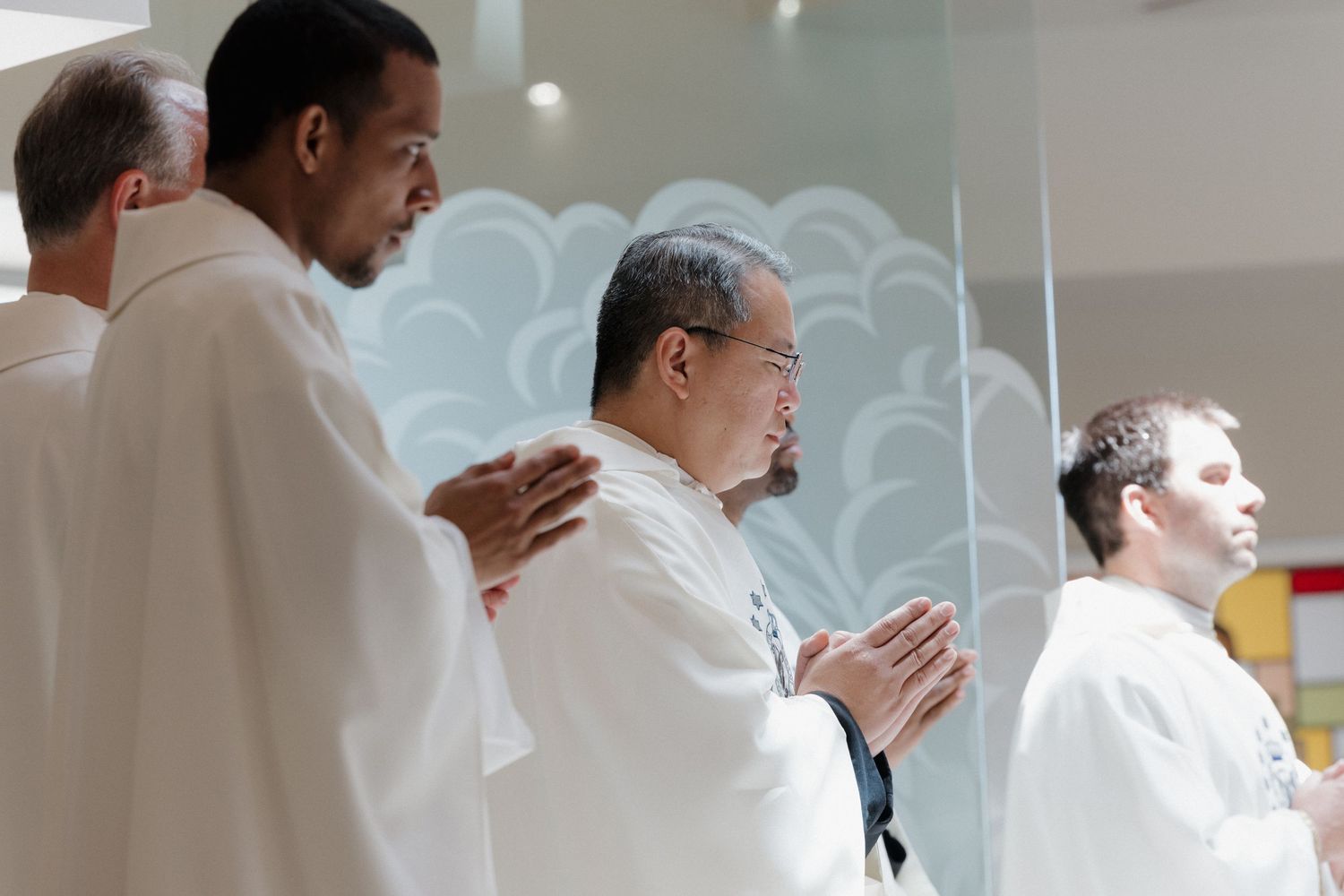 People in white ceremonial robes standing in formation during service.