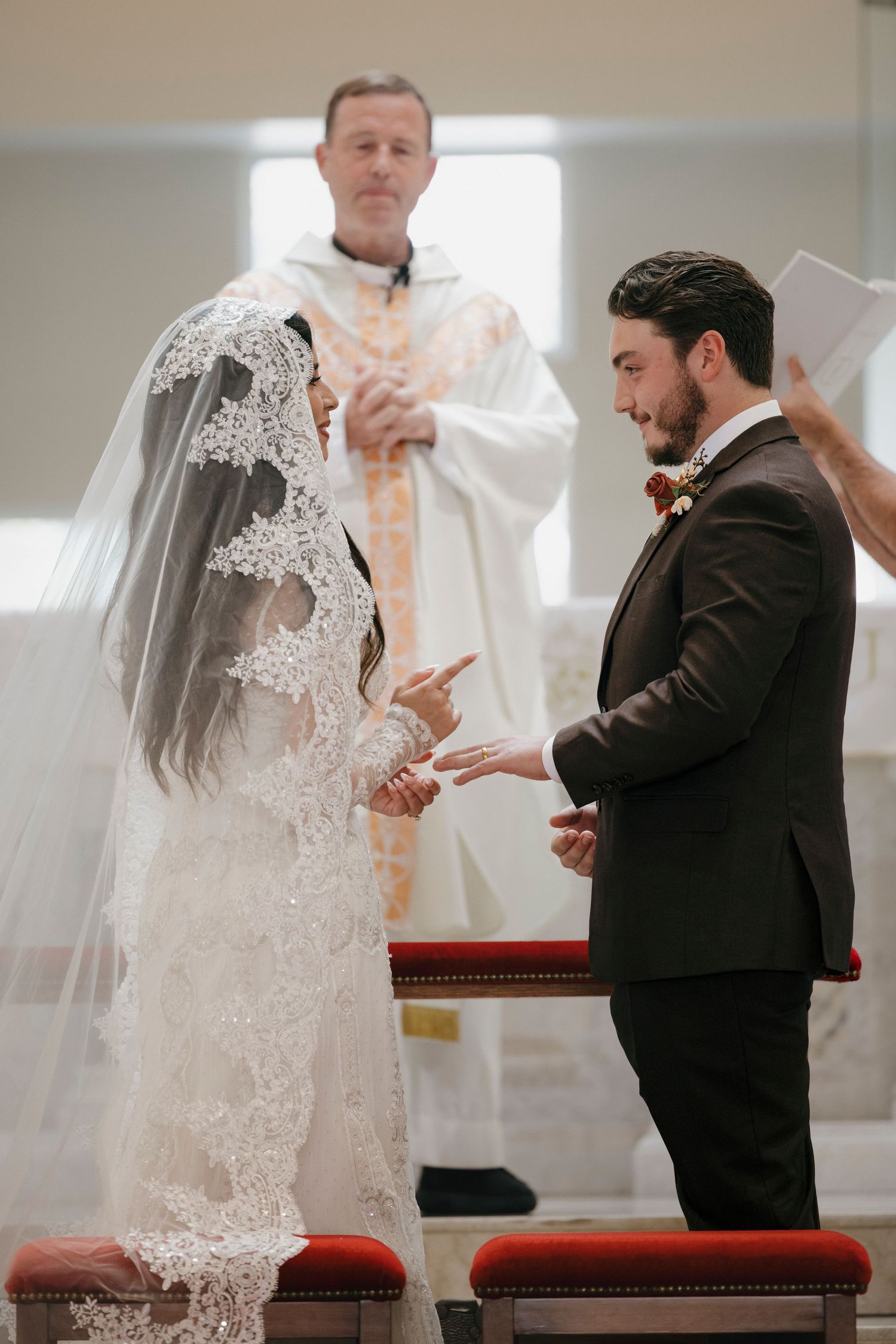 A wedding ceremony taking place at the altar with clergy and attendees.