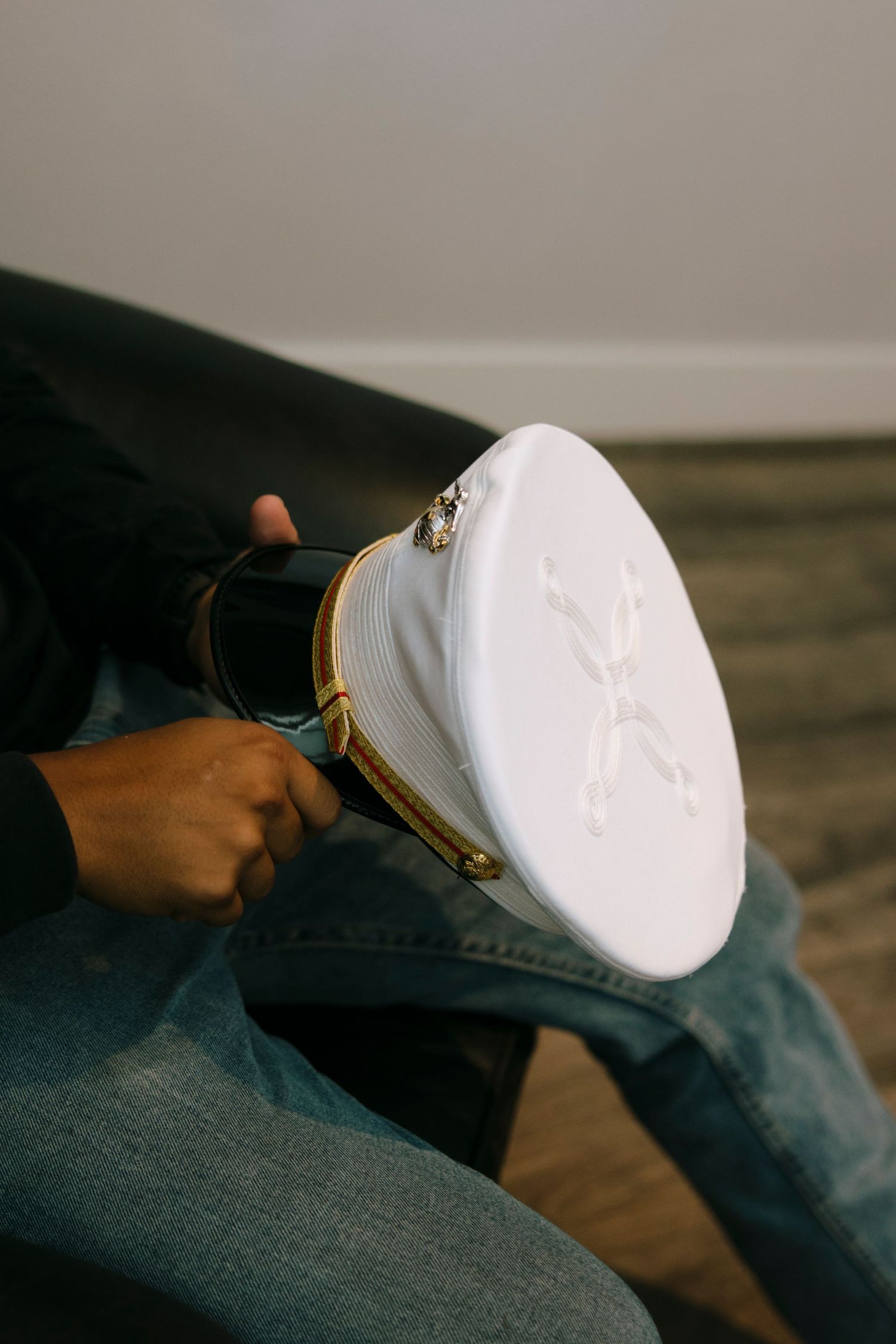 Close-up shot of a white baseball cap being adjusted on someone's lap.