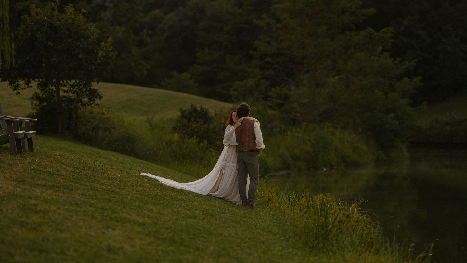 A dreamy outdoor wedding setup with white fabric and floral arrangements in a natural landscape.