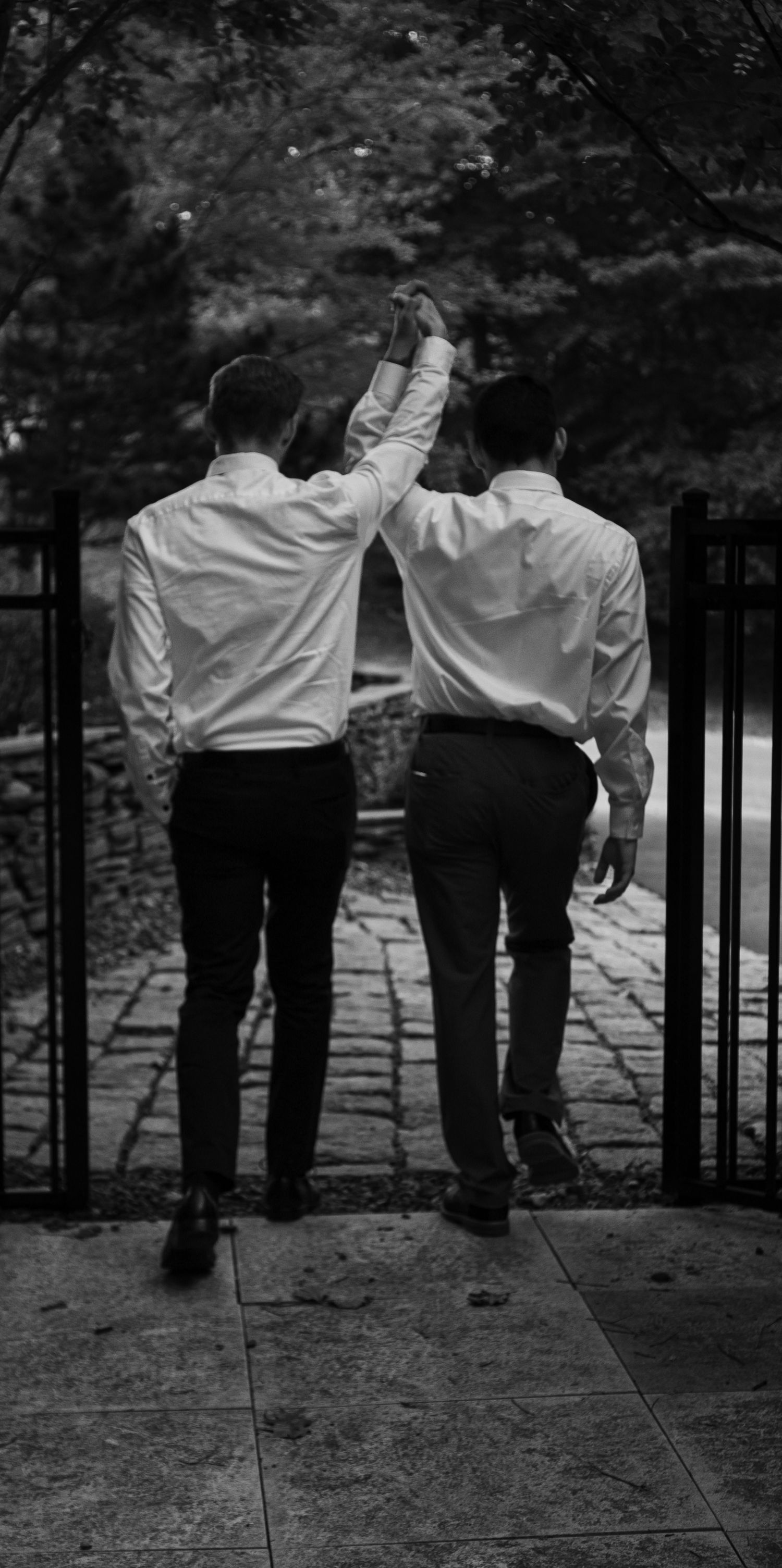 LGBTQ Newlyweds walking down a stone path in Alexandria, Virginia.