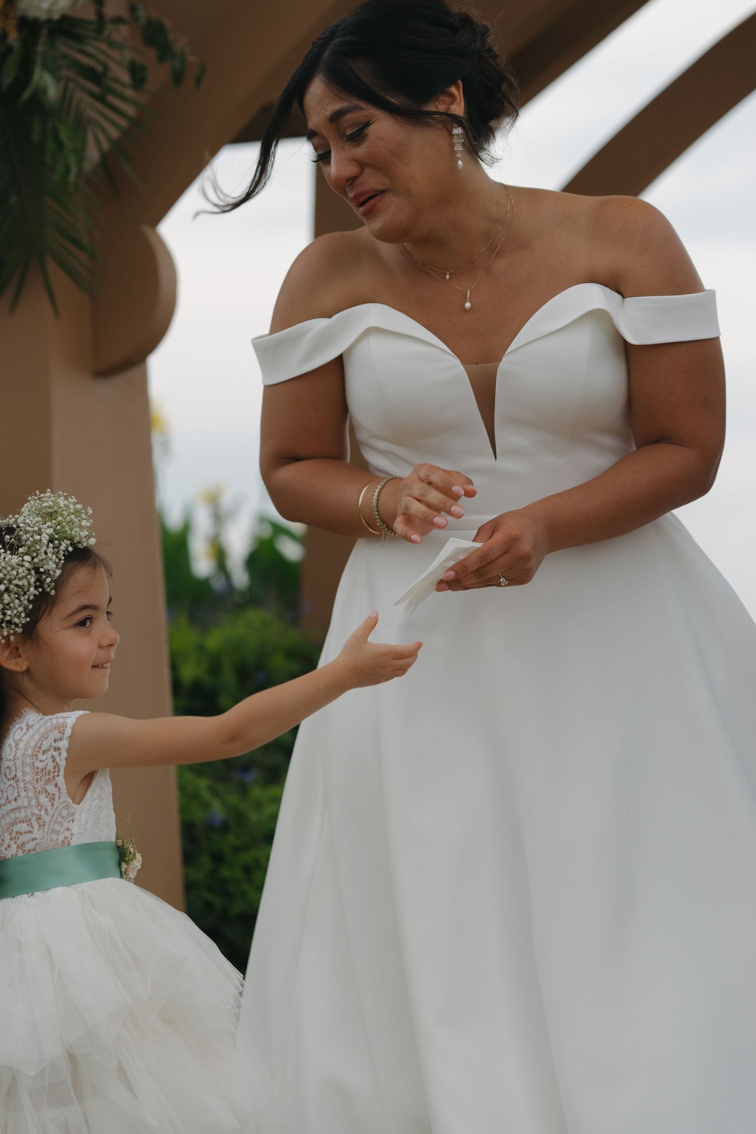 Bridesmaids in white dresses preparing for a wedding ceremony.