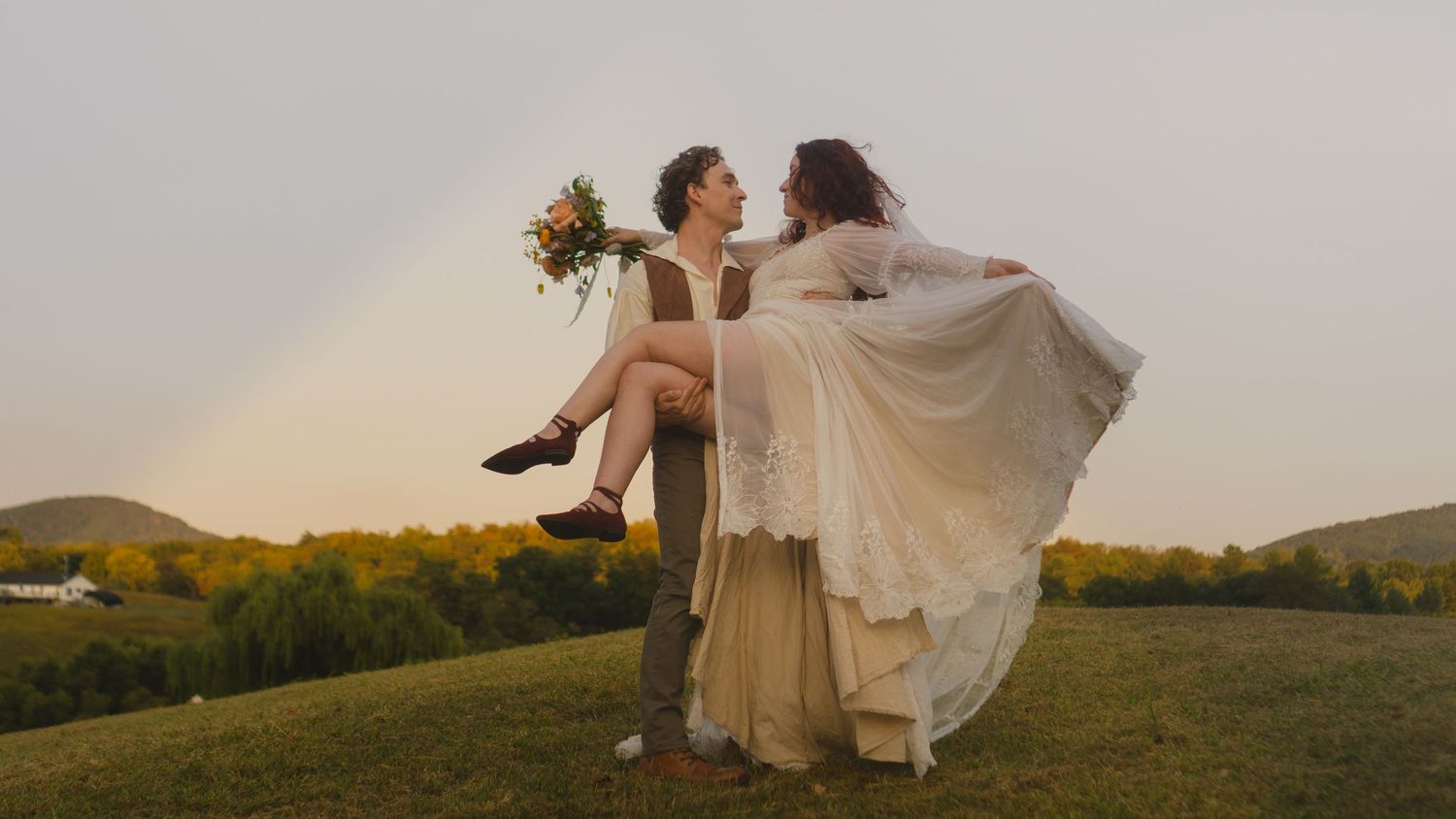 A romantic wedding photoshoot in a golden field at sunset with flowing white dress and veil.
