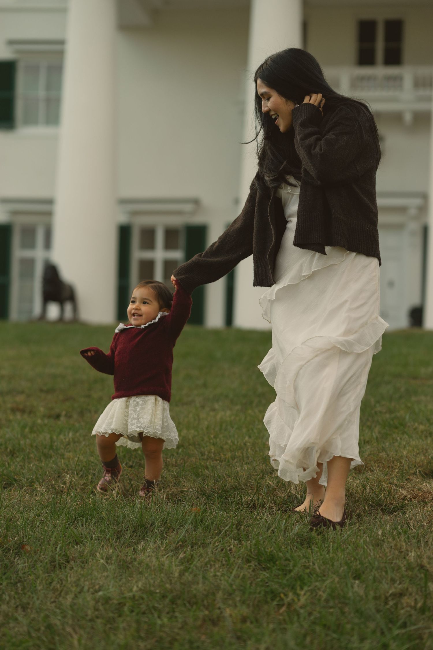 A sequence of images shows a playful game of chase between two people on a grassy lawn outside a building.