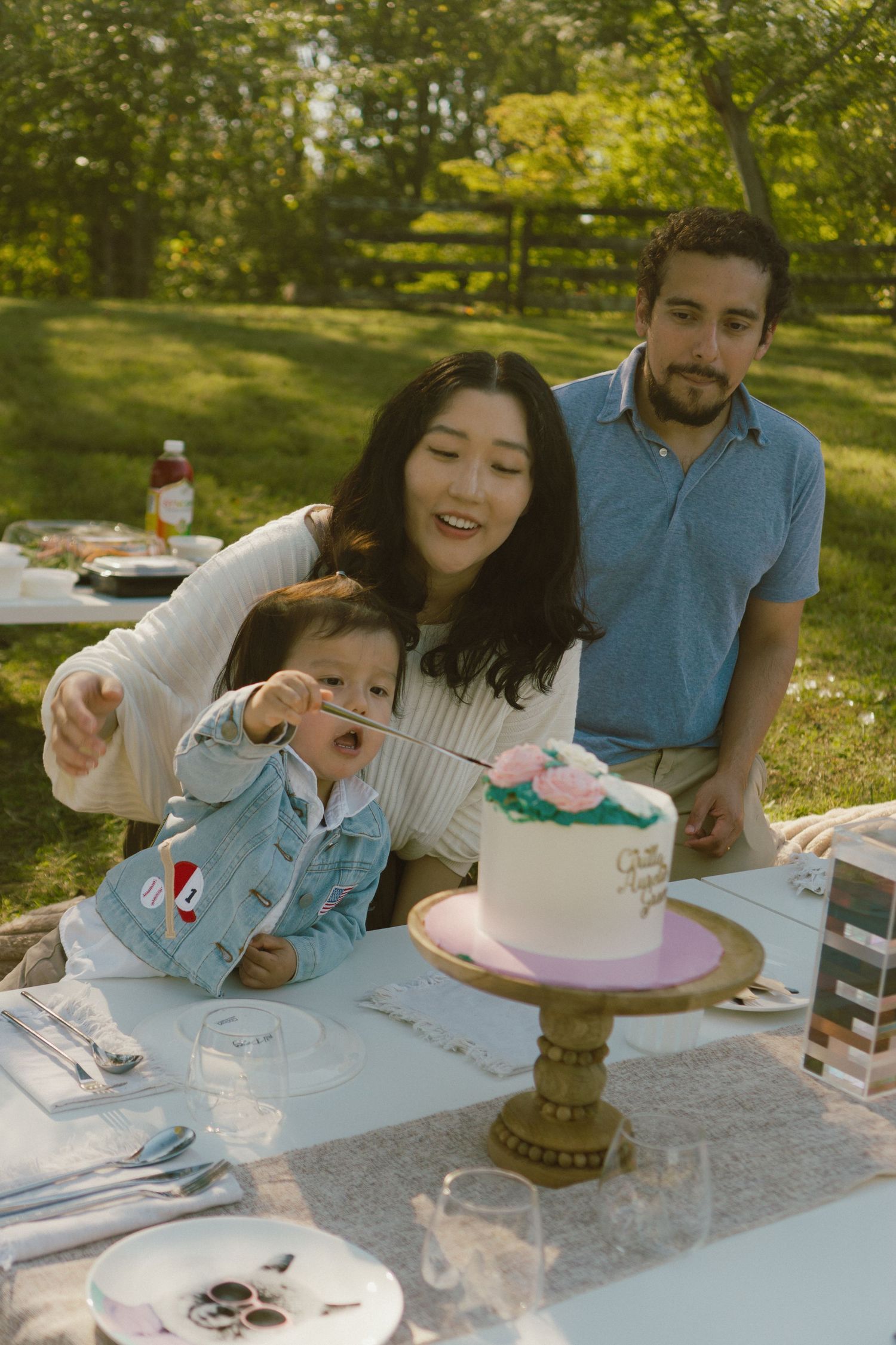 Family enjoying cake decorating together at an outdoor picnic table. Alpaca Farm Upper Marlboro, Maryland.