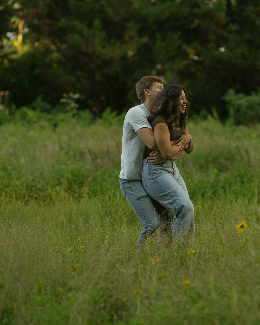 A couple spinning around in a luscious open field