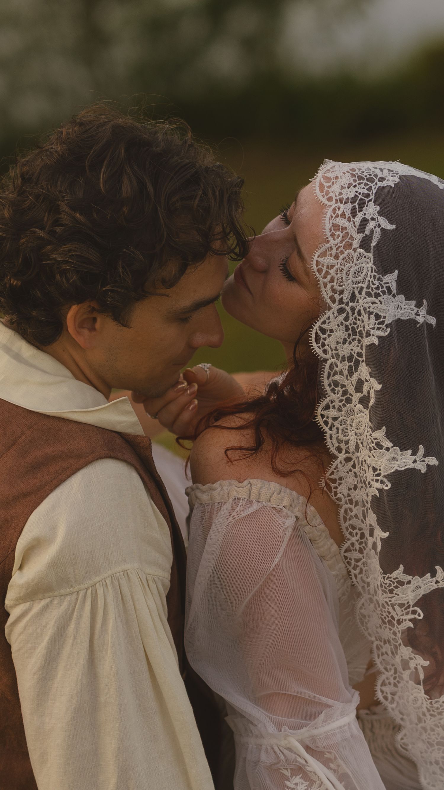 An intimate wedding moment captured with delicate lace veil details at golden hour.