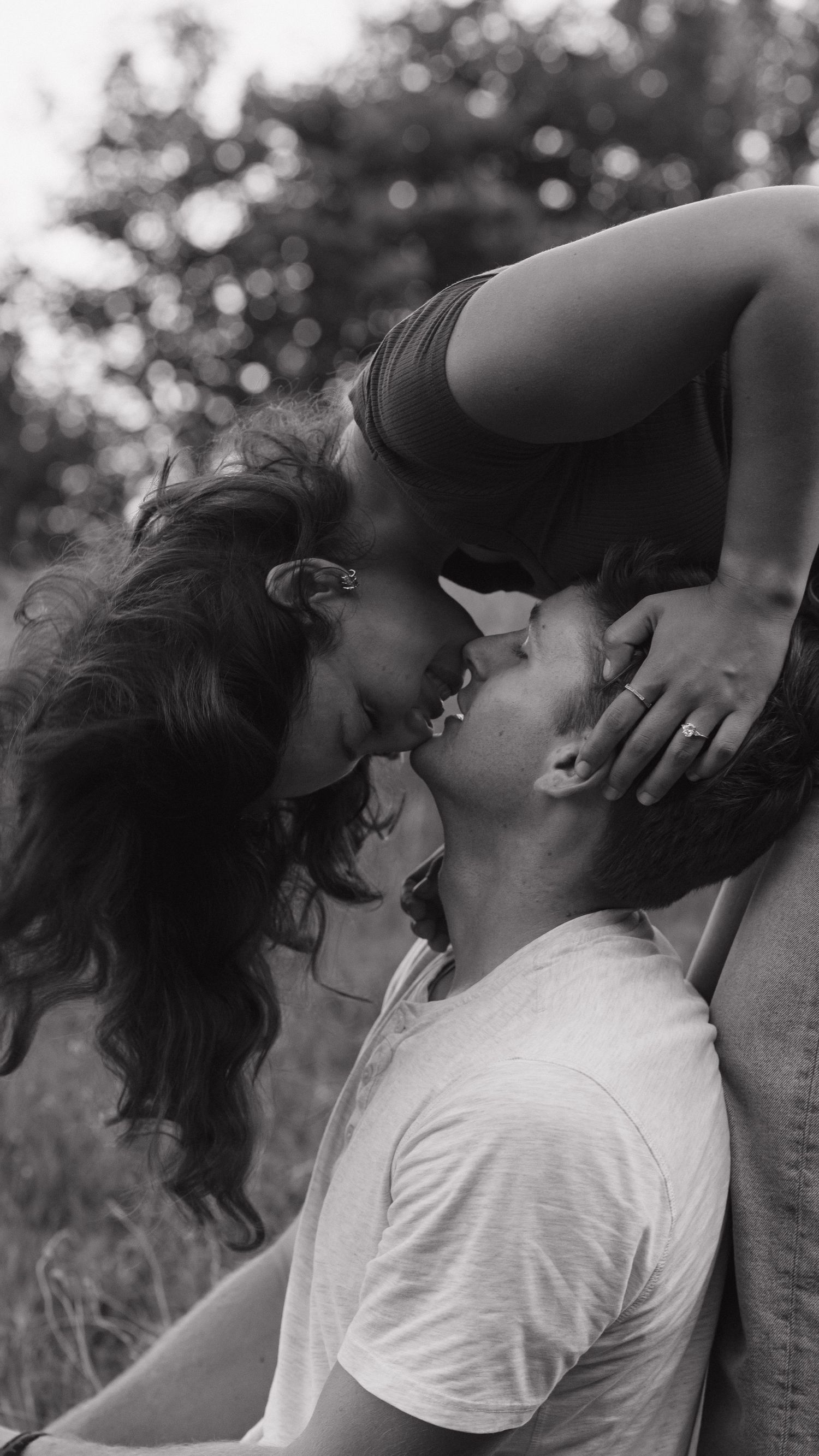 A romantic black and white photo sequence showing a couple sharing an intimate kiss outdoors.