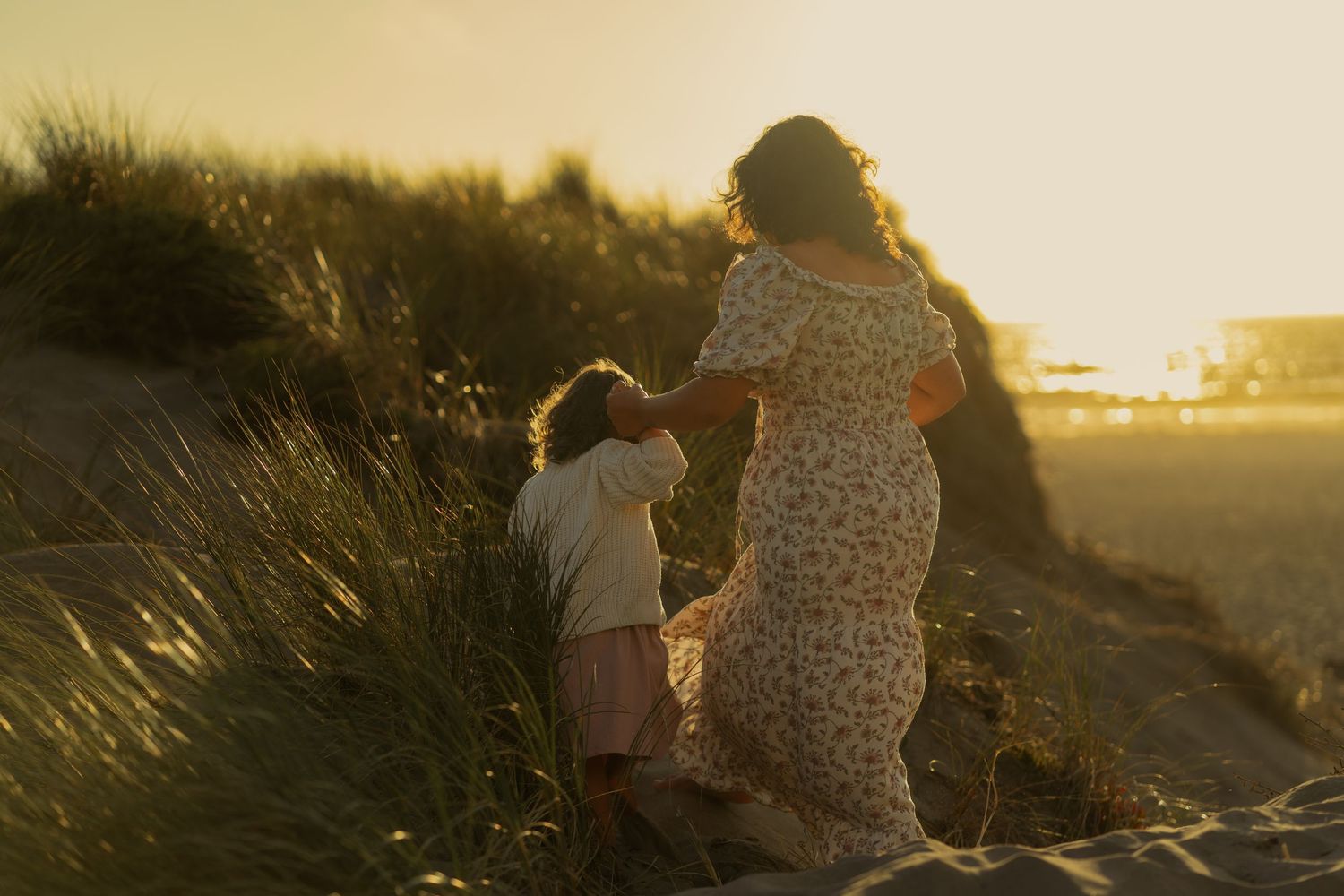 Two figures walking along a scenic coastal path at golden hour. Dillon Beach, California.