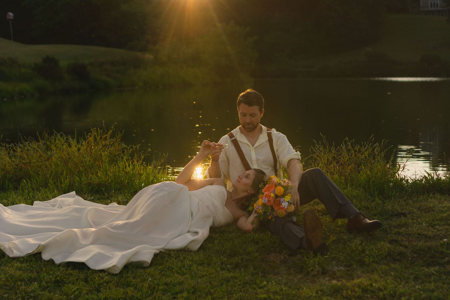 Romantic sunset photoshoot in a grassy field with golden sunlight streaming through the trees.