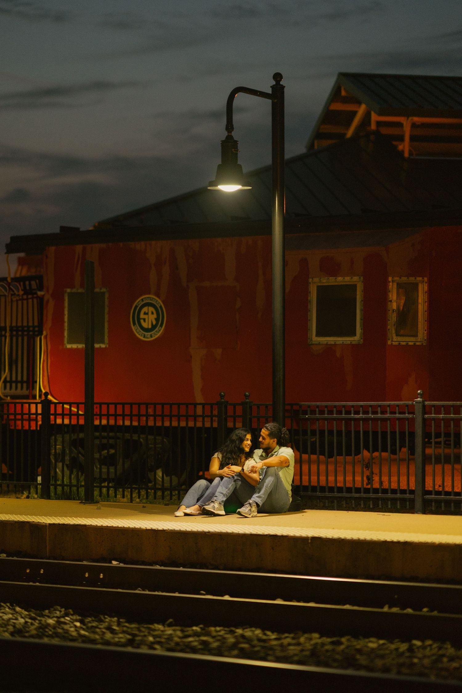 Couple at a train station in Manassas, Virginia, sitting under a lamp post