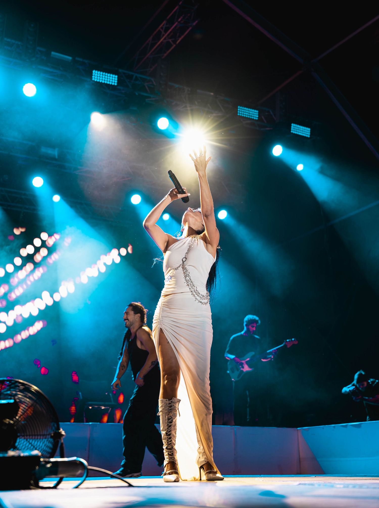 Stage performance with dramatic blue lighting and silhouetted figures.