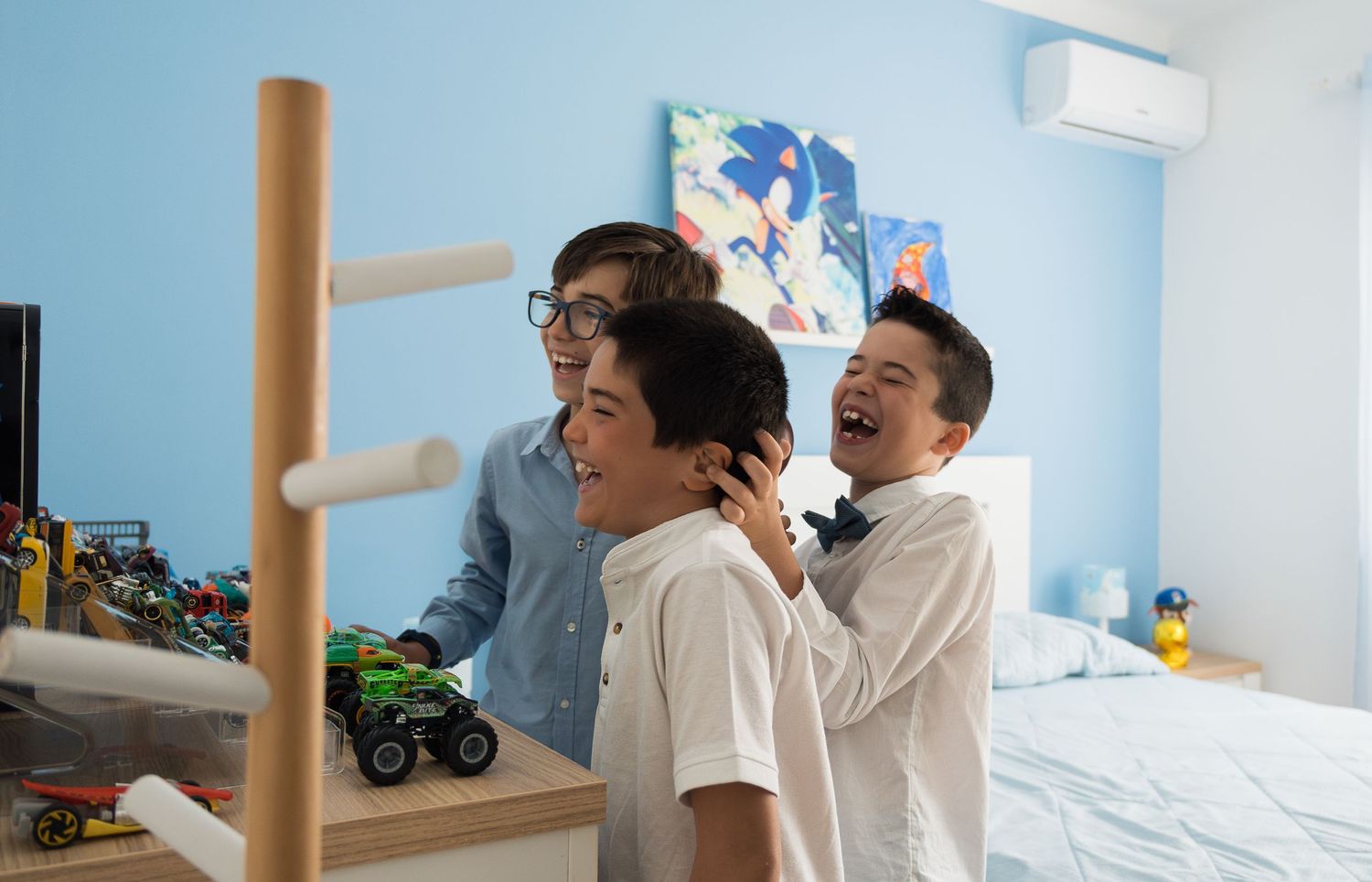 People gathered in bedroom with blue walls and playful decorations.