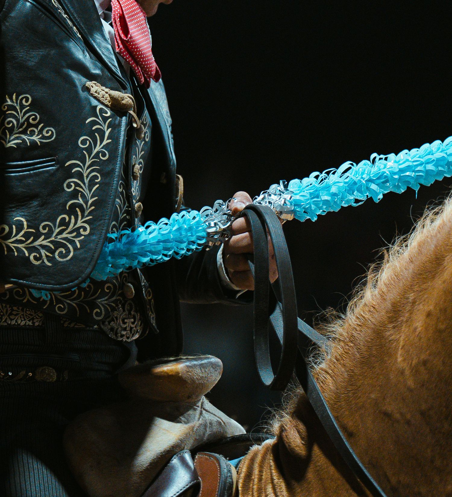Close-up of ornate western saddle details with turquoise accents.