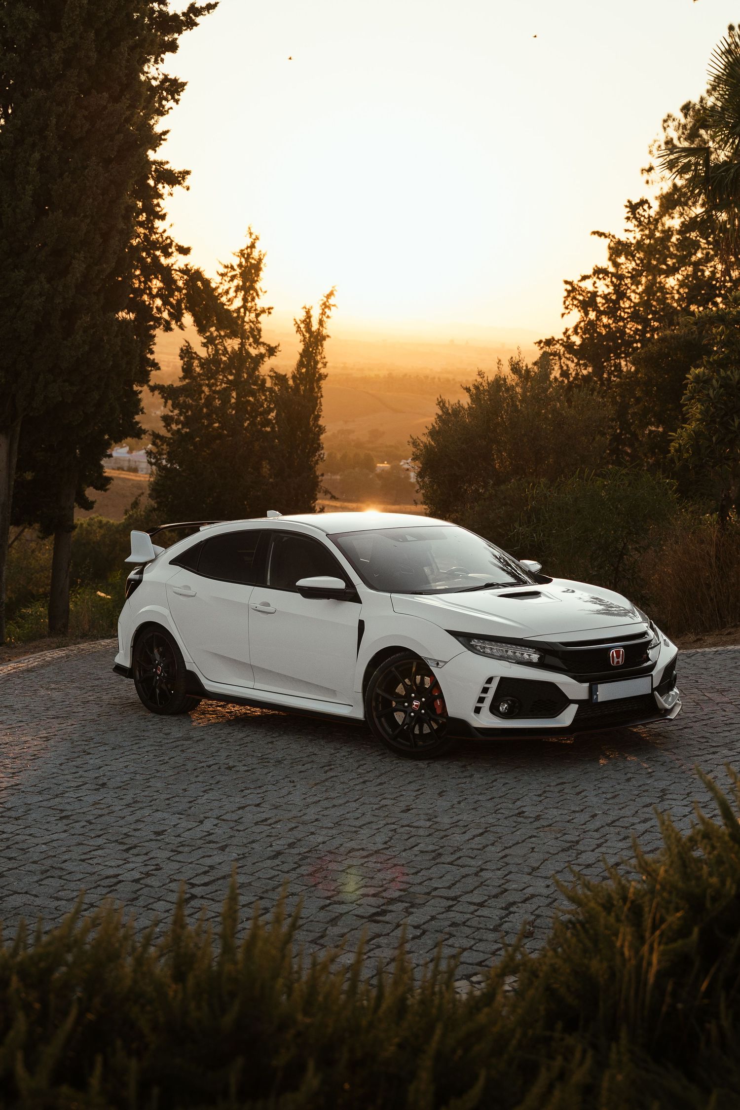 White Honda Civic Type R photographed at sunset against scenic mountain backdrop.