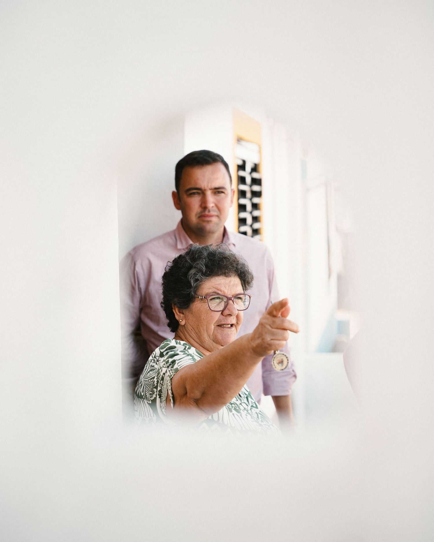 People gesturing and interacting in a bright white interior space.
