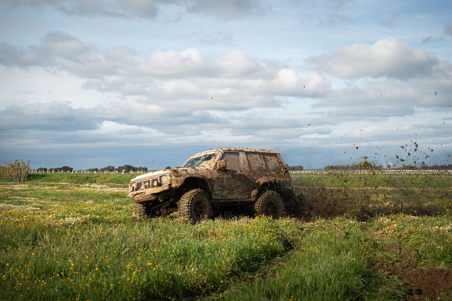 Panoramic sequence of abandoned rusty cars in a grassy field against a cloudy sky.