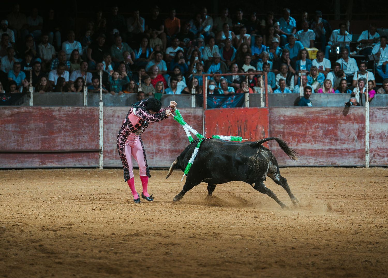 Sequence of action shots showing a bullfight in a traditional arena with matador and bull in dramatic confrontation.