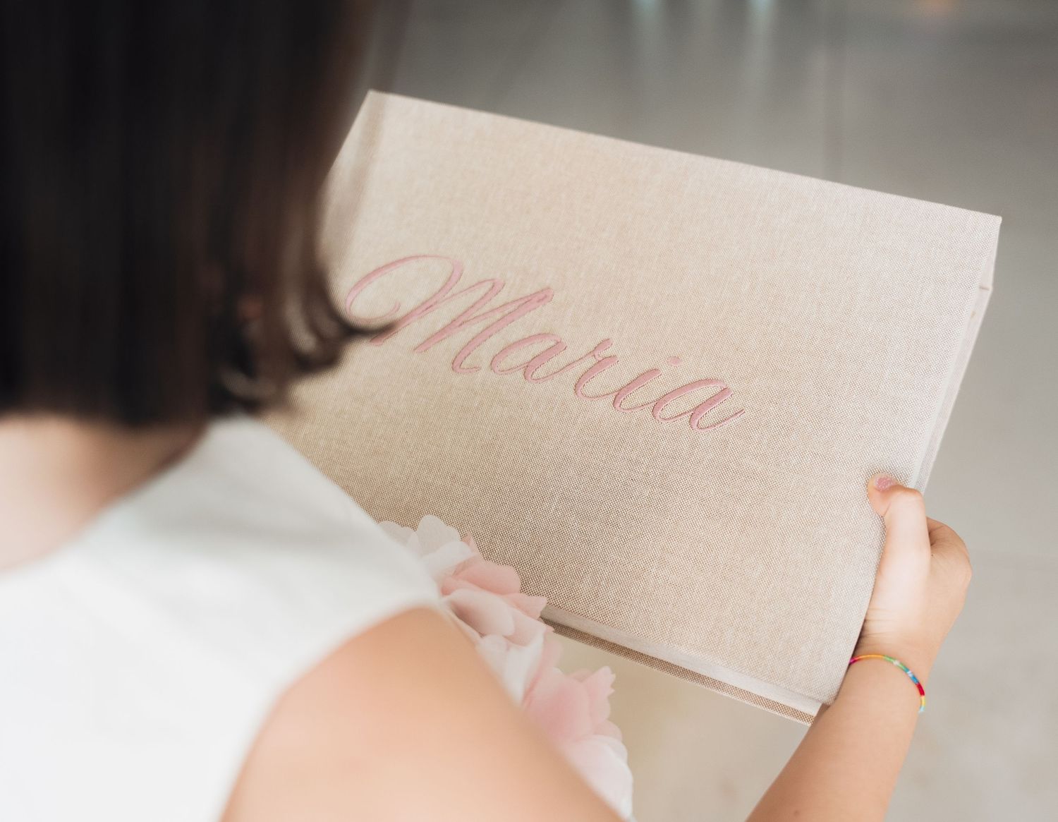 Close-up of hands holding elegant paper with Maria written in script.