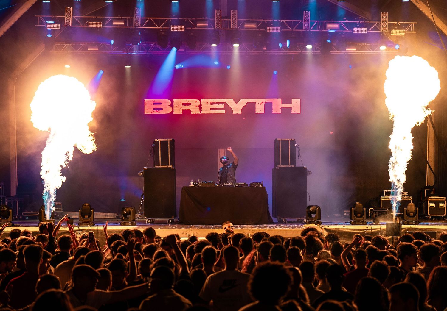Concert stage with Breyth branding and pyrotechnic effects above energetic crowd.