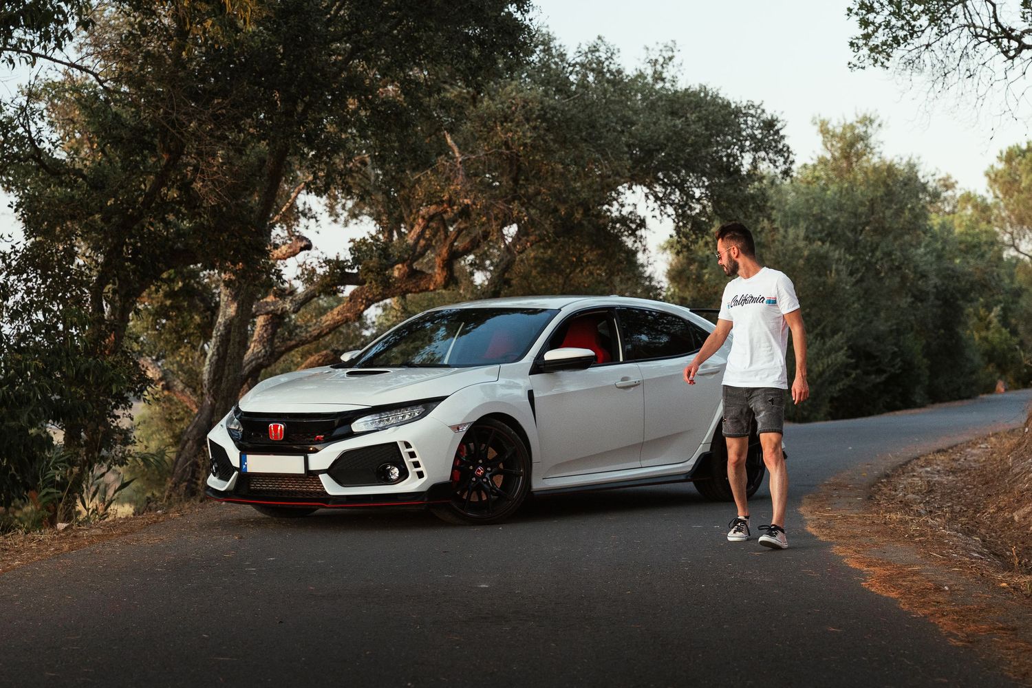 White Honda Civic Type R parked on a scenic mountain road during golden hour.