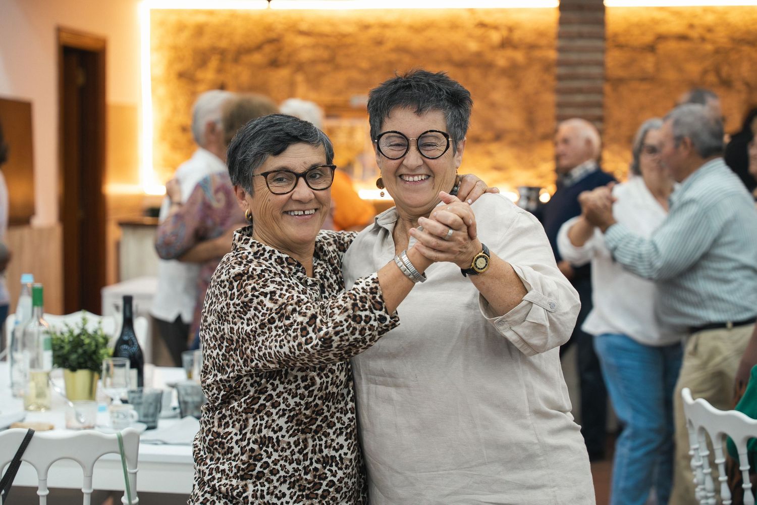 Two people enjoying a lighthearted moment at an indoor social event.