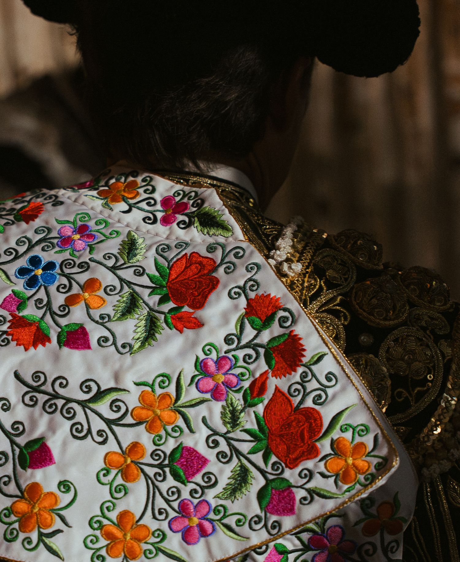 Traditional embroidered fabric with colorful floral patterns and swirls.