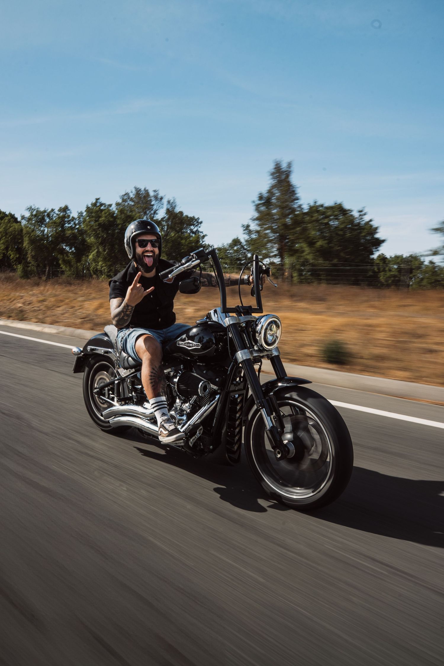 Custom motorcycle photographed in dynamic motion on an empty country road.