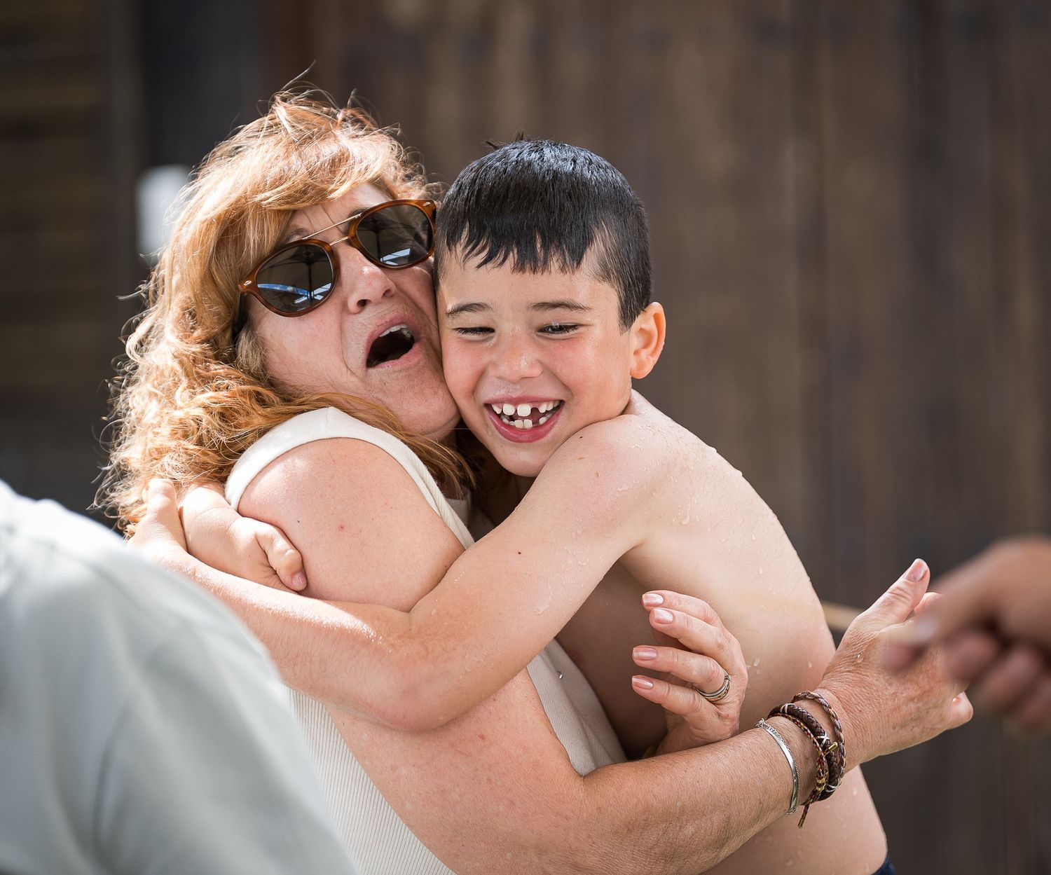 Candid moments of joy and laughter shared during outdoor wedding celebration.