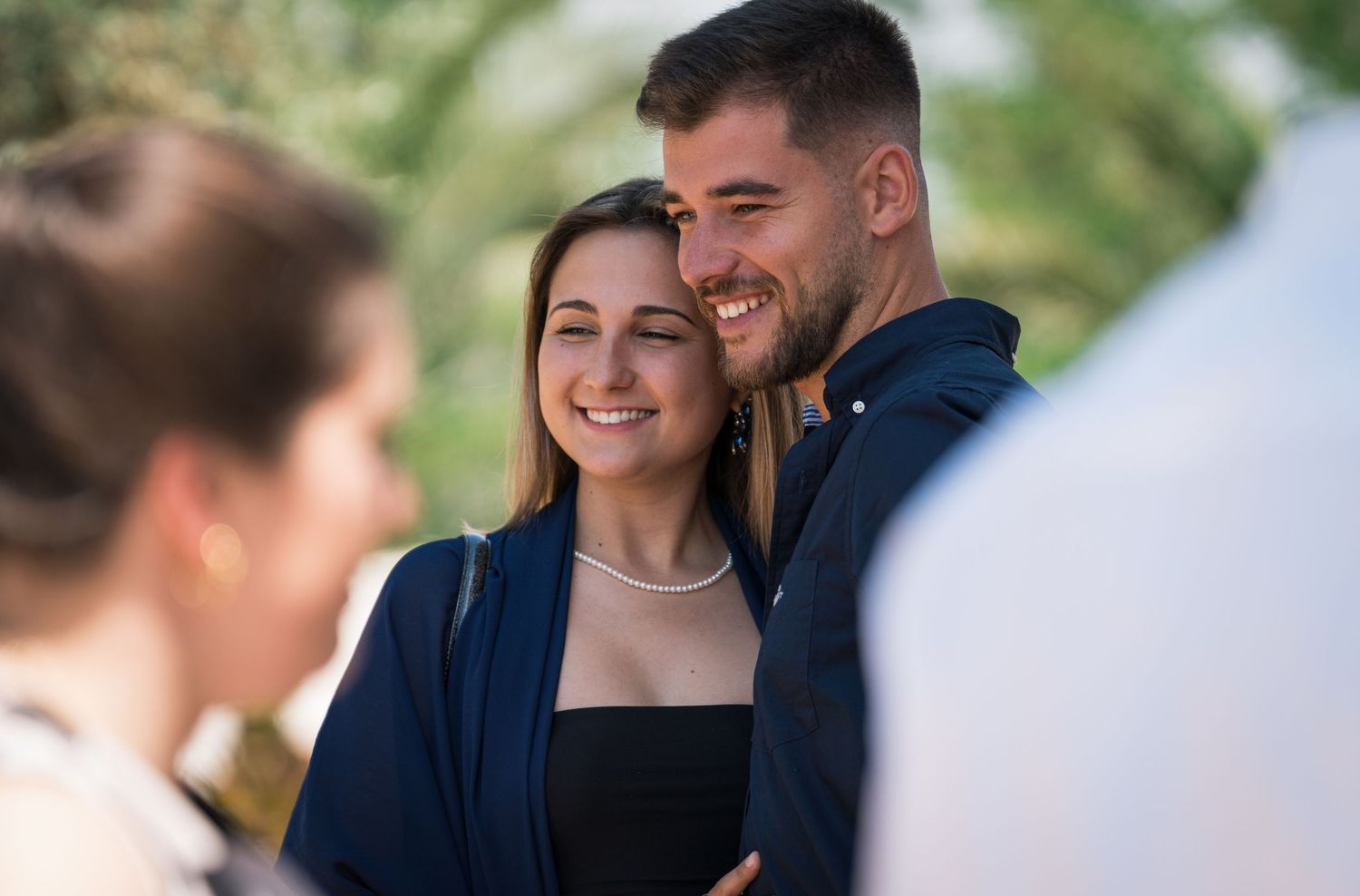Couple sharing intimate moment at outdoor gathering.