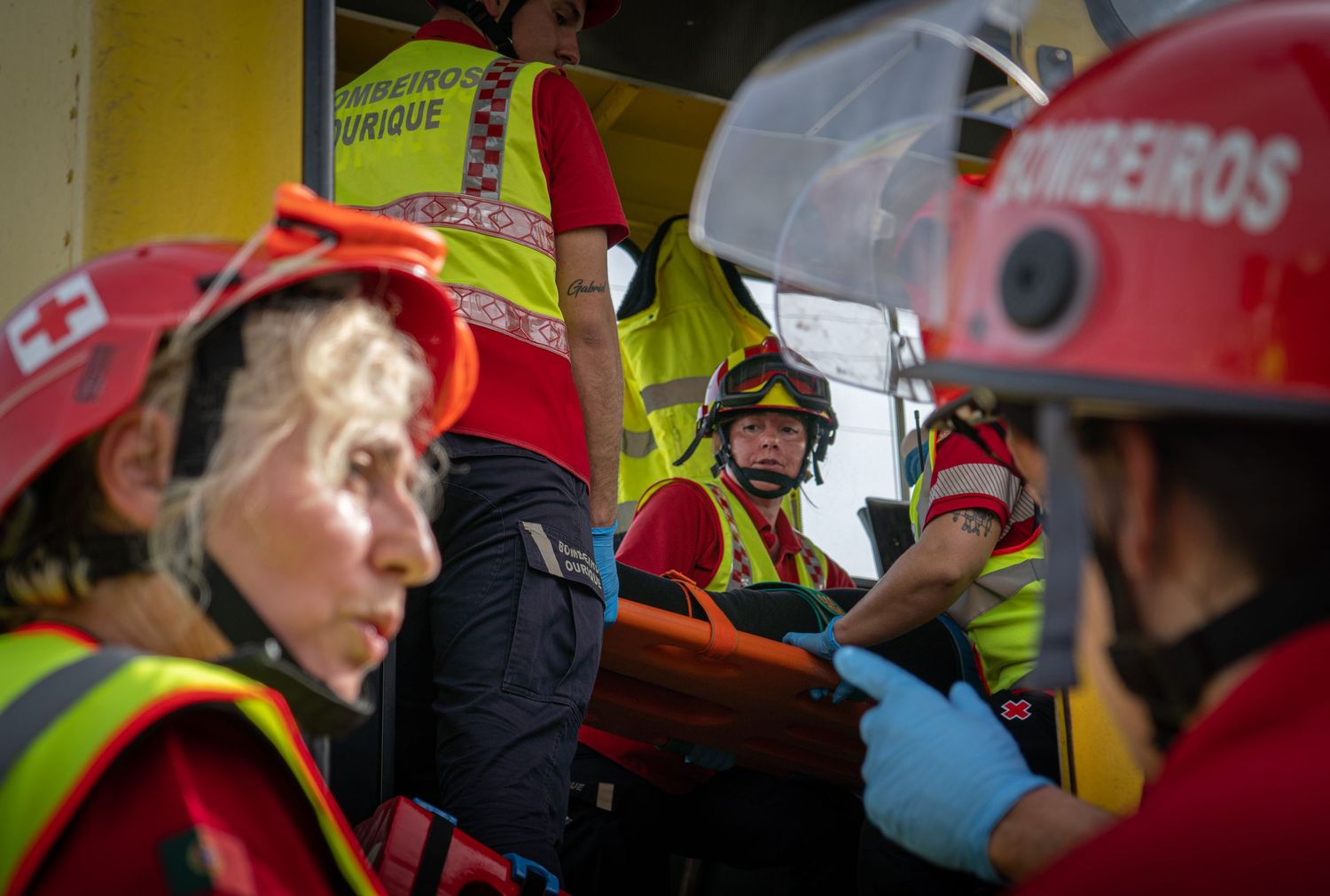 Emergency responders in safety gear and helmets during a training exercise.