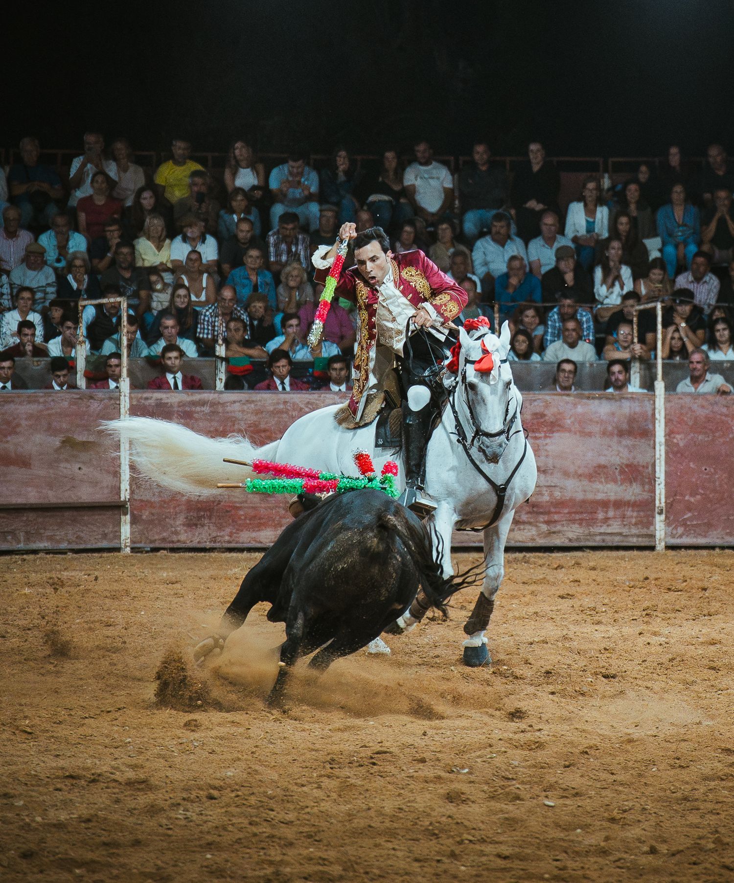A sequence of bullfighting action shots showing a bull charging and performers evading in a sandy arena.