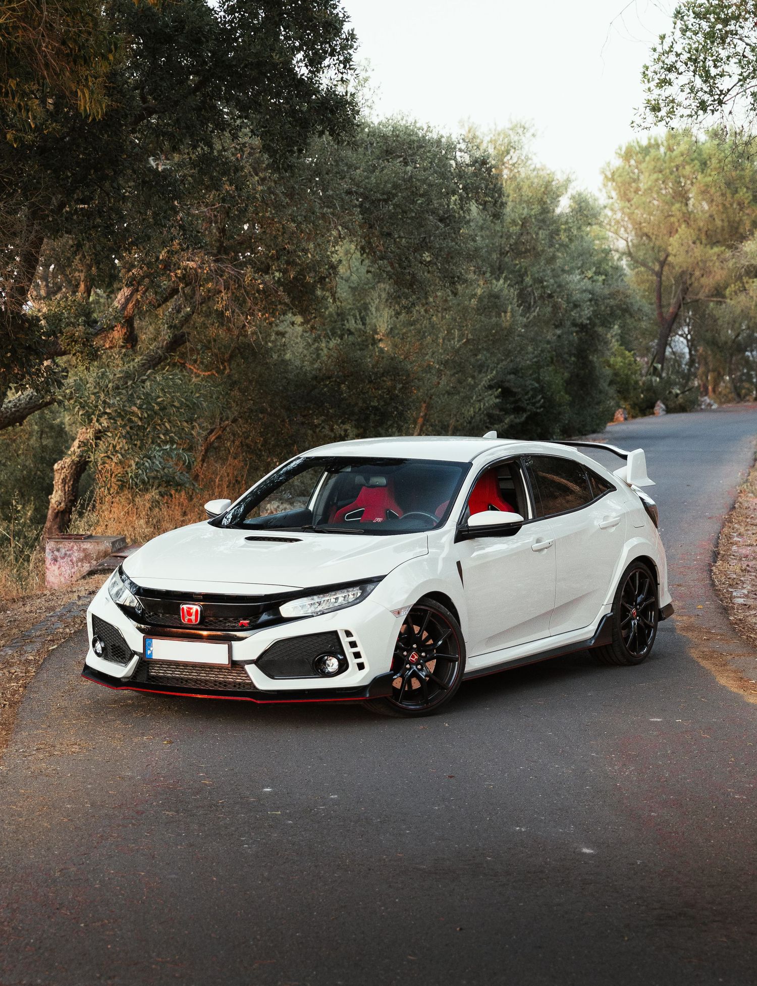 Lowered white Honda Civic Type R showcasing aggressive stance and body modifications.