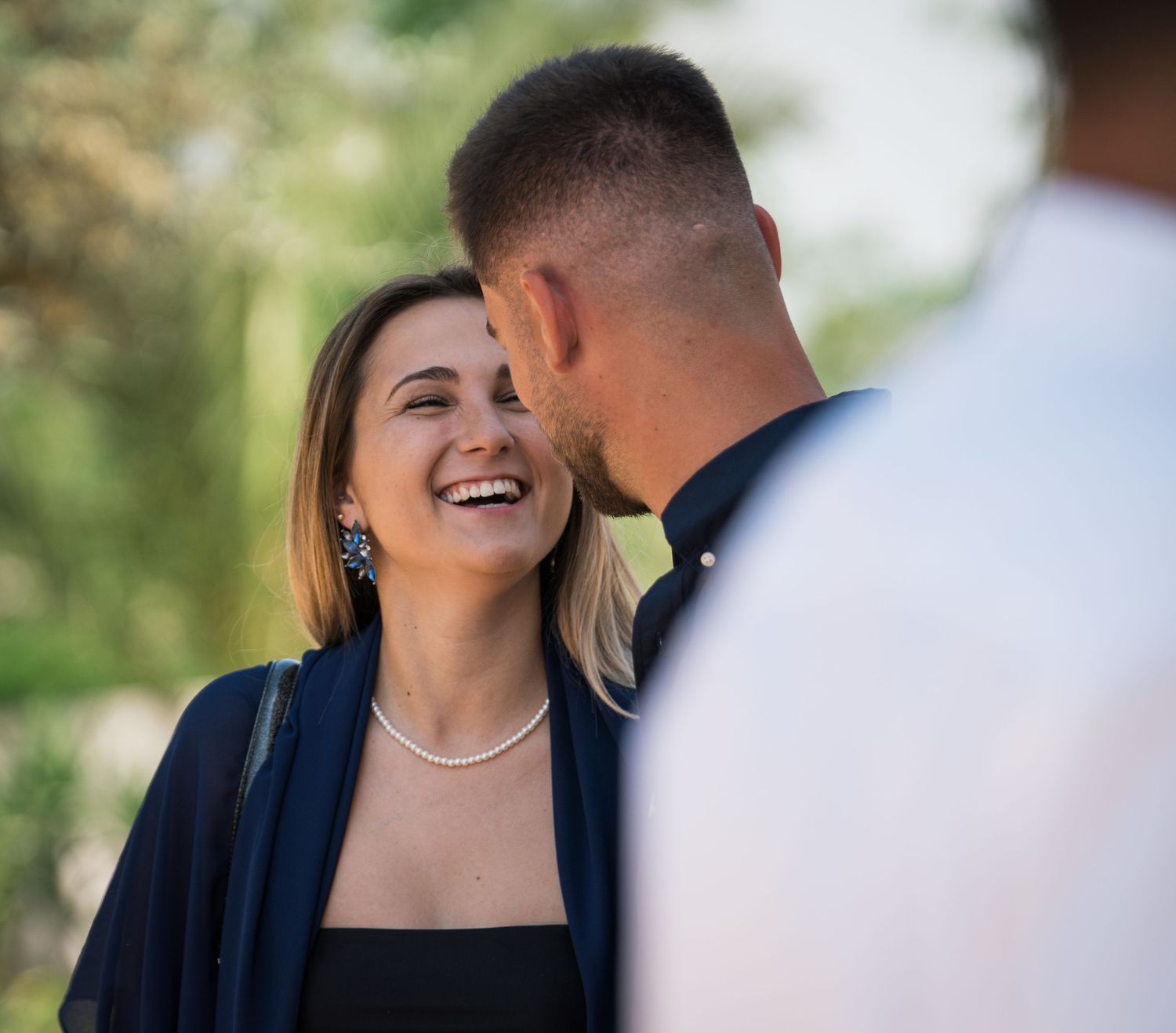 Couple sharing laughter during outdoor celebration.