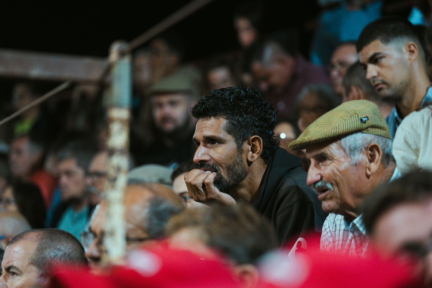 Spectators watching intently from the stands during a bullfighting event.