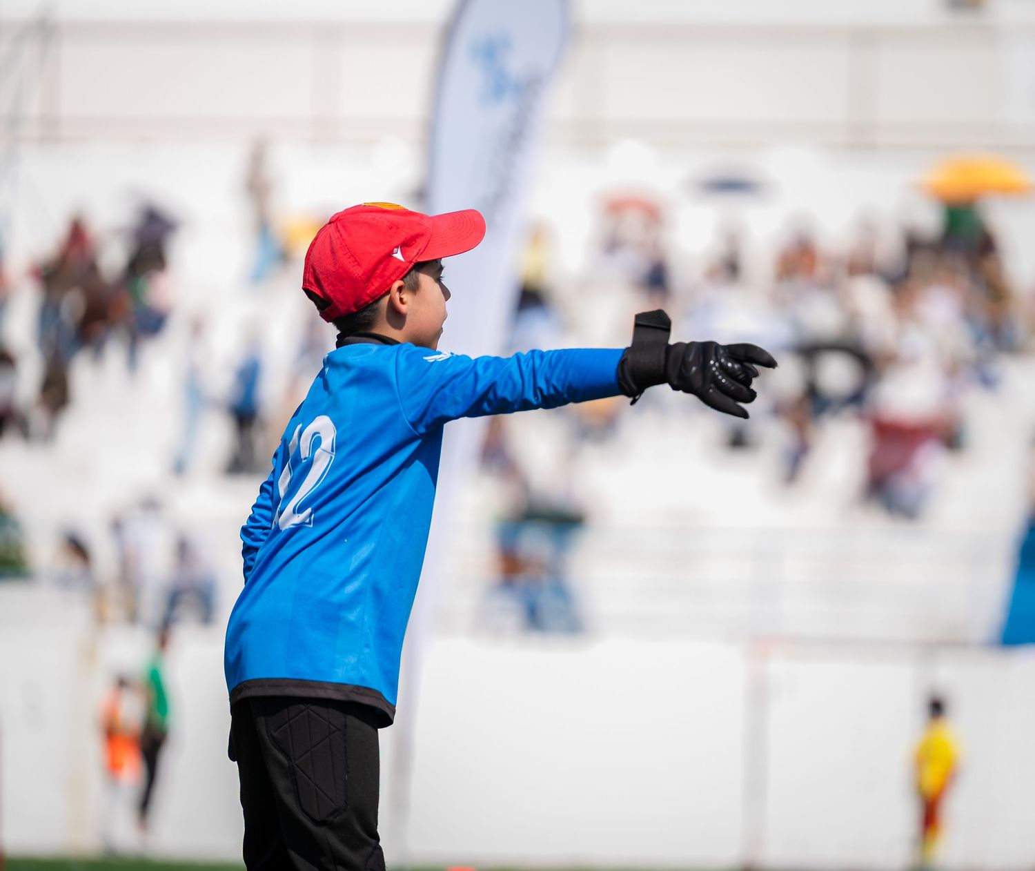 Soccer player in blue jersey practicing shooting drills on outdoor field.