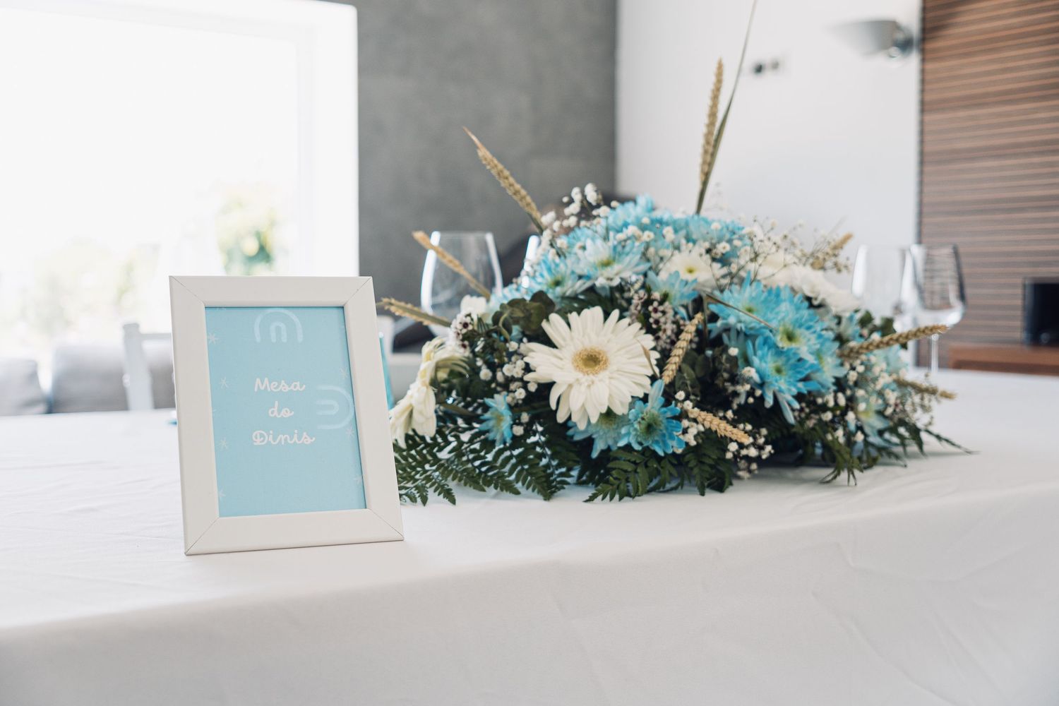Minimalist wedding decor featuring turquoise accents and white floral arrangements on tables.